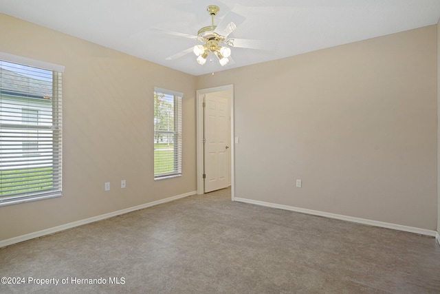 carpeted spare room with ceiling fan and a healthy amount of sunlight