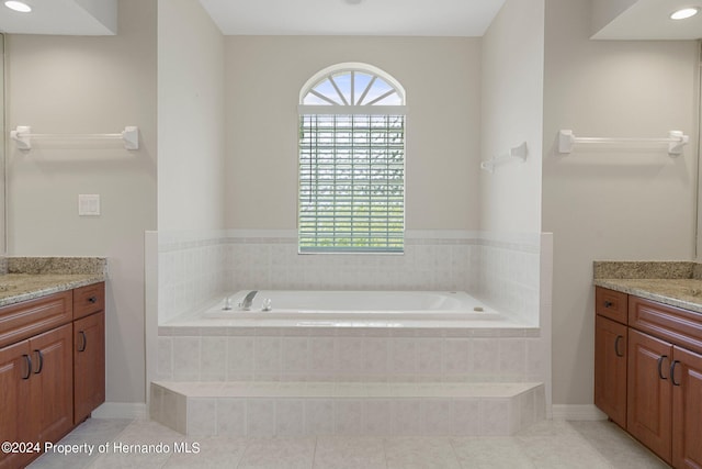 bathroom with vanity, tile patterned flooring, and tiled tub