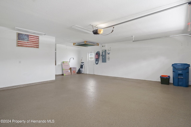 garage with a garage door opener and electric panel