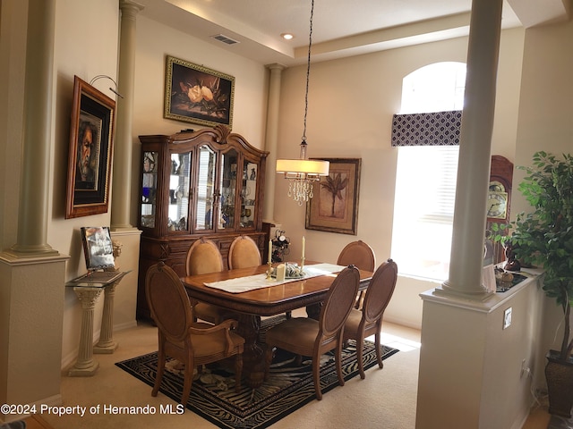 carpeted dining space featuring decorative columns