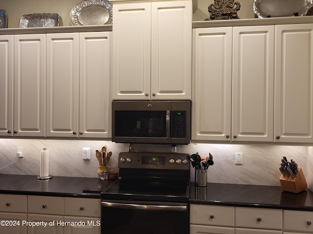 kitchen featuring white cabinets, stainless steel appliances, and tasteful backsplash