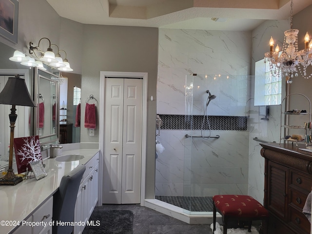 bathroom featuring vanity, an inviting chandelier, and tiled shower