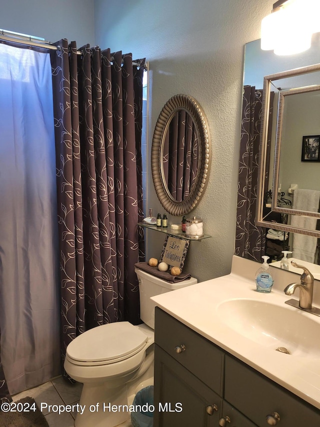 bathroom featuring tile patterned floors, vanity, and toilet