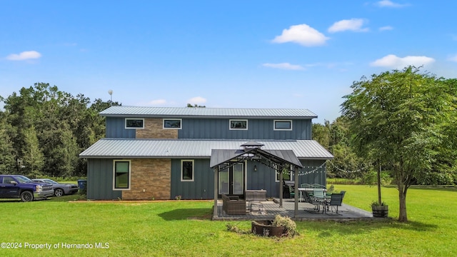 rear view of property with a lawn, a gazebo, and a patio area