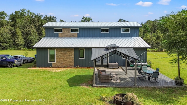 back of property with a deck, a lawn, and outdoor lounge area