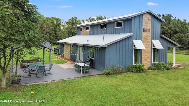 back of property with a yard and a patio area