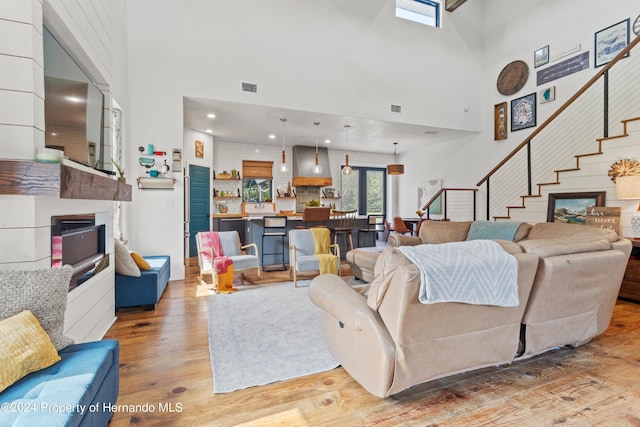 living room with light hardwood / wood-style flooring and a towering ceiling