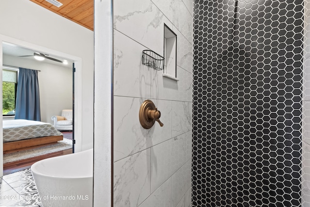 bathroom with tiled shower, a skylight, wood ceiling, and ceiling fan