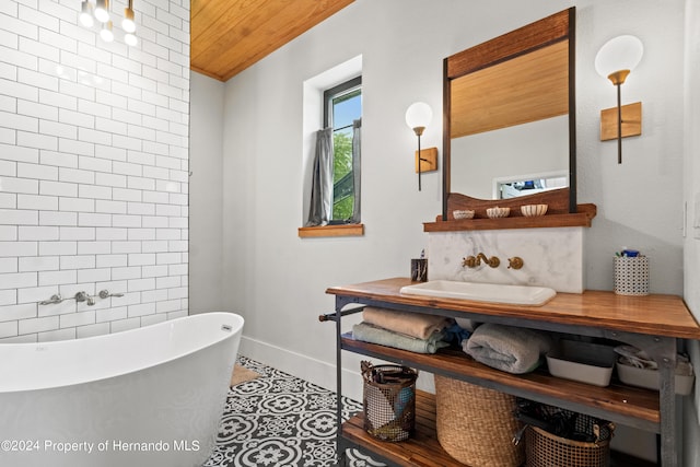 bathroom featuring vanity, a bath, wood ceiling, and tile patterned flooring