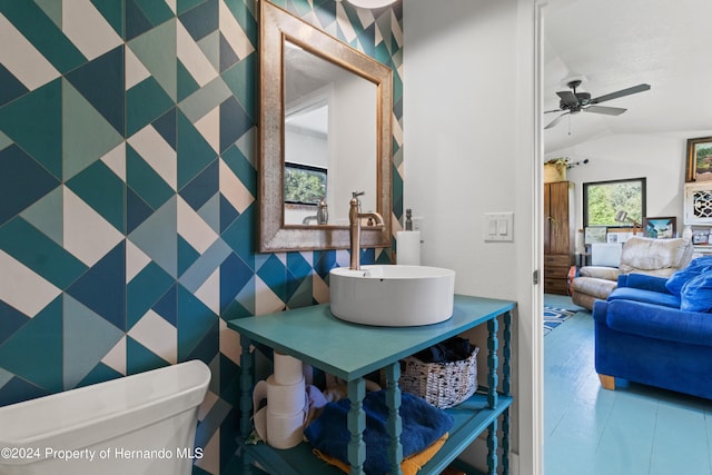 bathroom featuring lofted ceiling, sink, toilet, and ceiling fan