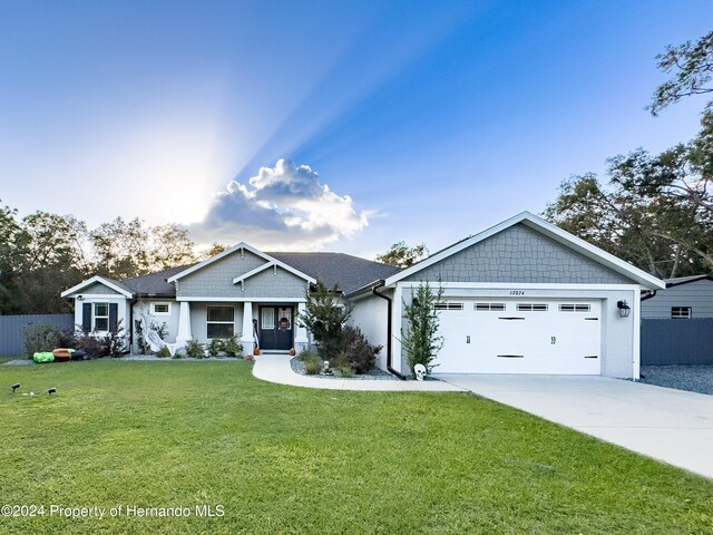 craftsman house with a garage and a front lawn