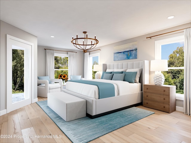 bedroom with access to exterior, light wood-type flooring, and a notable chandelier