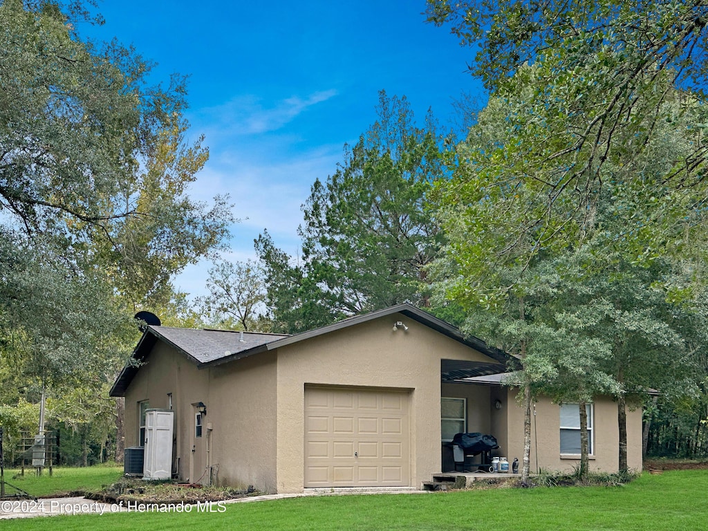 view of front of house featuring a front lawn and a garage