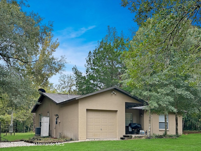 view of front of house featuring a front lawn and a garage