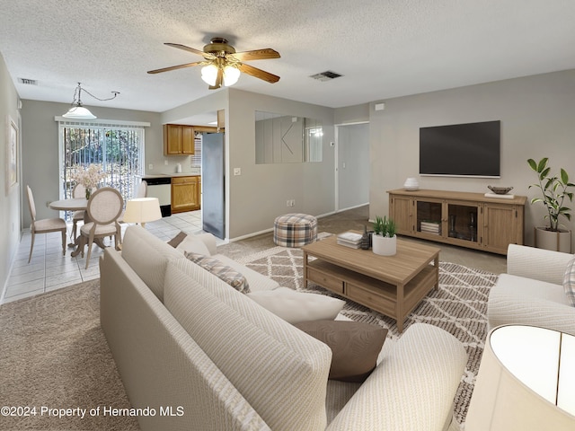 carpeted living room featuring ceiling fan and a textured ceiling