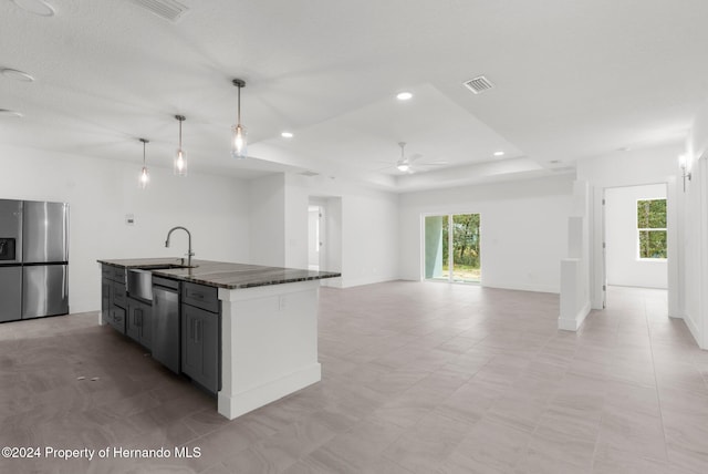 kitchen with a kitchen island with sink, stainless steel appliances, a healthy amount of sunlight, and pendant lighting