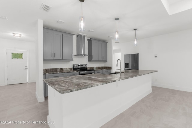 kitchen with stainless steel appliances, dark stone countertops, wall chimney range hood, gray cabinetry, and pendant lighting