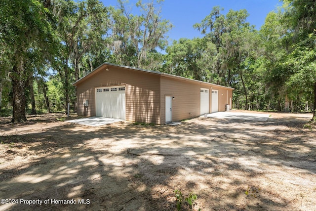 view of property exterior with a garage and an outdoor structure