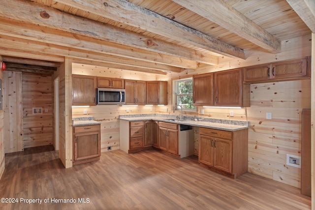 kitchen with hardwood / wood-style floors, appliances with stainless steel finishes, and wooden walls