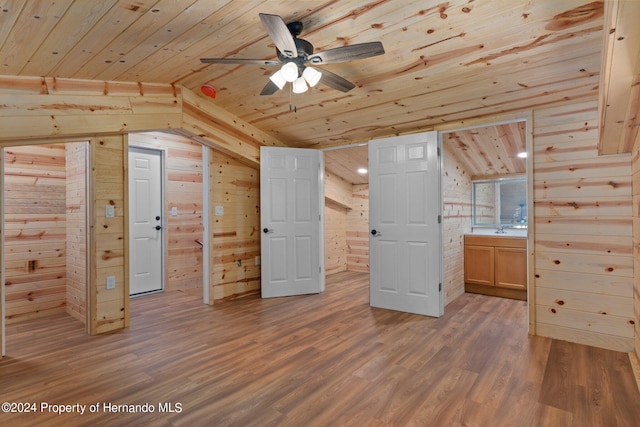 bonus room featuring lofted ceiling, wood-type flooring, wood walls, wooden ceiling, and ceiling fan