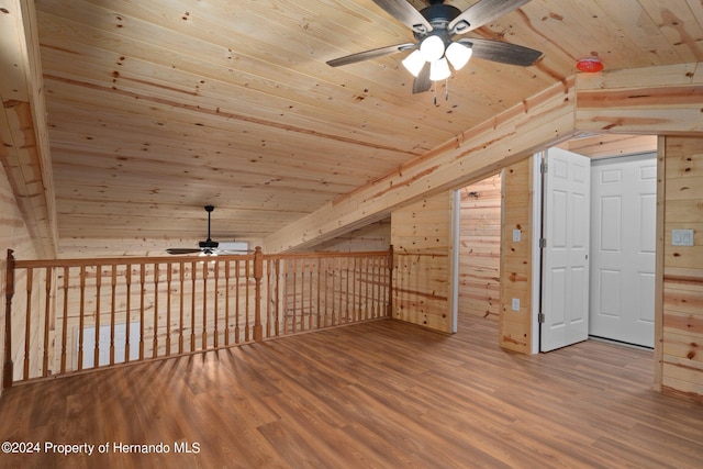 bonus room with wooden ceiling, hardwood / wood-style flooring, wood walls, and vaulted ceiling