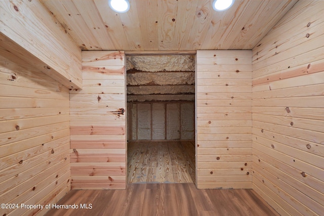 interior space featuring wood walls, hardwood / wood-style floors, and wooden ceiling