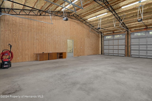 garage featuring a garage door opener and wooden walls