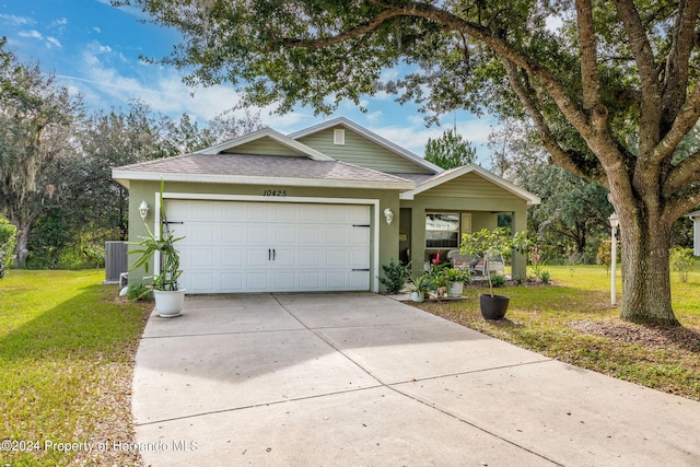 view of front of house with a front lawn, central air condition unit, and a garage