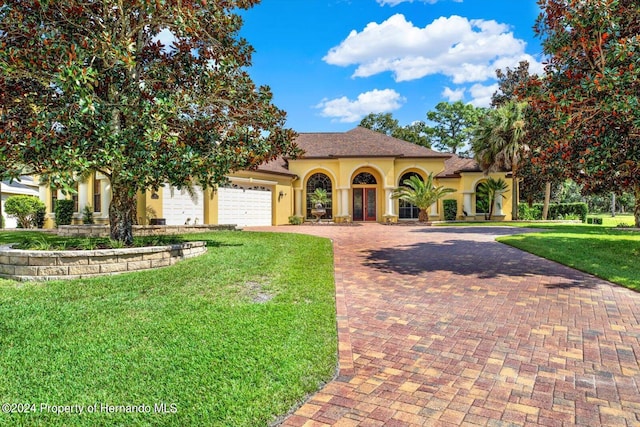 view of front facade with a garage and a front lawn