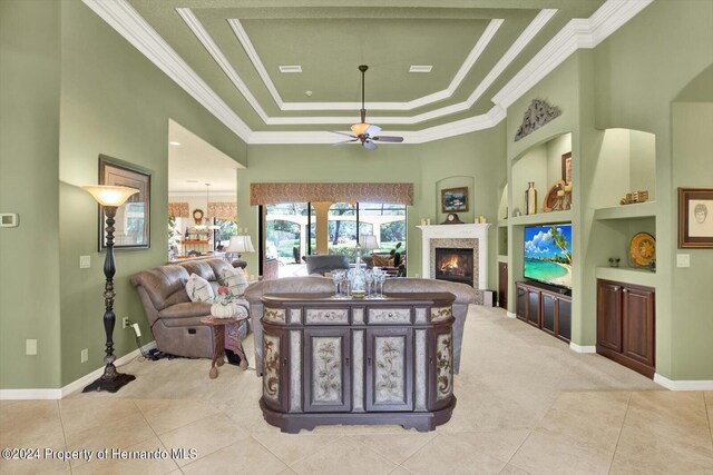 dining area with built in shelves, a raised ceiling, light tile patterned floors, and ceiling fan with notable chandelier