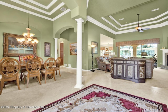 dining room featuring light colored carpet, a raised ceiling, crown molding, and decorative columns