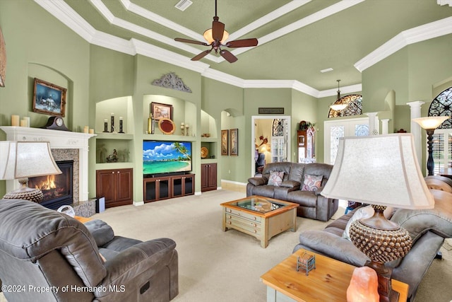 carpeted living room featuring decorative columns, a towering ceiling, ceiling fan, and crown molding