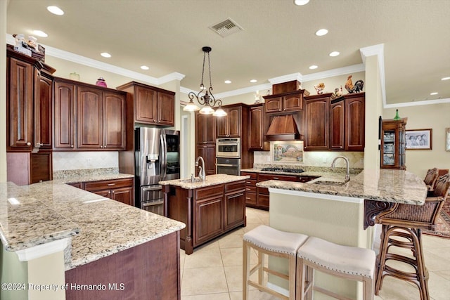 kitchen with a kitchen bar, a center island with sink, kitchen peninsula, light tile patterned floors, and appliances with stainless steel finishes