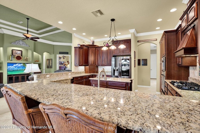 kitchen featuring stainless steel appliances, kitchen peninsula, ceiling fan, crown molding, and pendant lighting