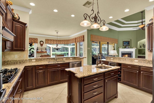 kitchen featuring hanging light fixtures, crown molding, sink, and kitchen peninsula