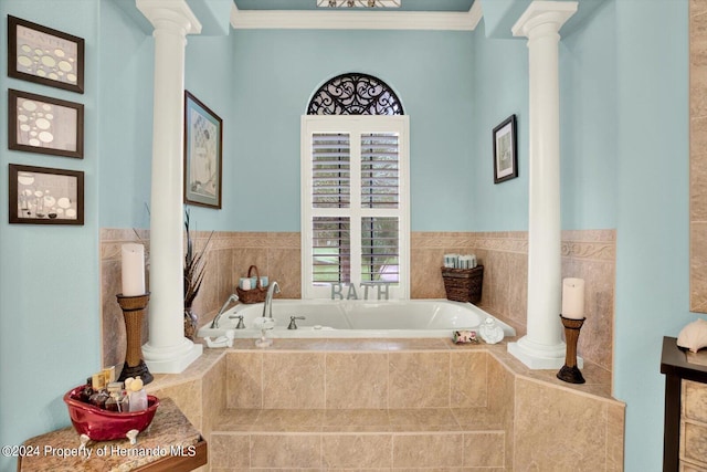 bathroom featuring decorative columns, ornamental molding, and tiled tub