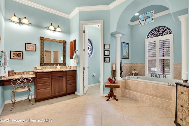 bathroom featuring vanity, decorative columns, a relaxing tiled tub, and ornamental molding