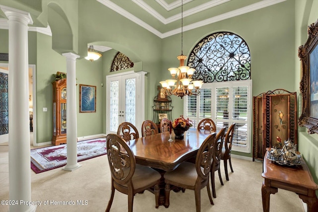 carpeted dining space with french doors, crown molding, ornate columns, a high ceiling, and a chandelier