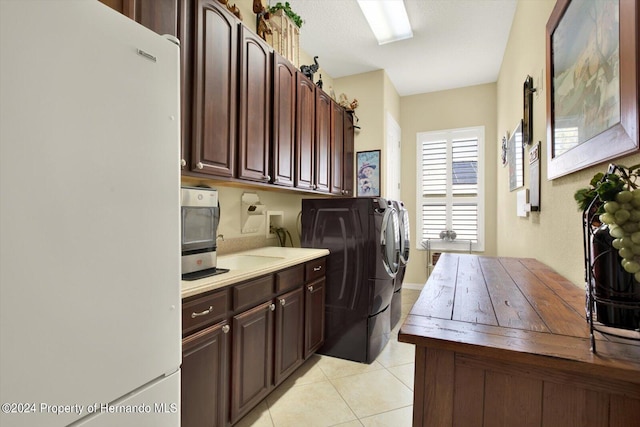 clothes washing area featuring washer and clothes dryer and light tile patterned flooring