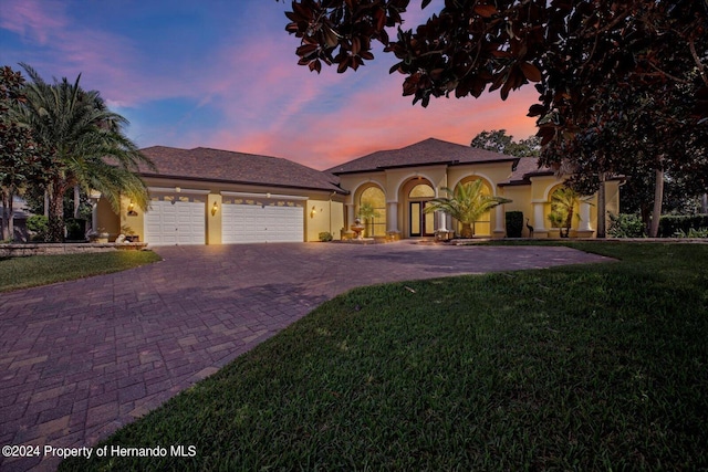 mediterranean / spanish house with a garage and a yard