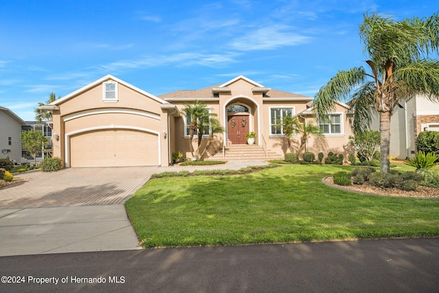 view of front of home with a garage and a front lawn