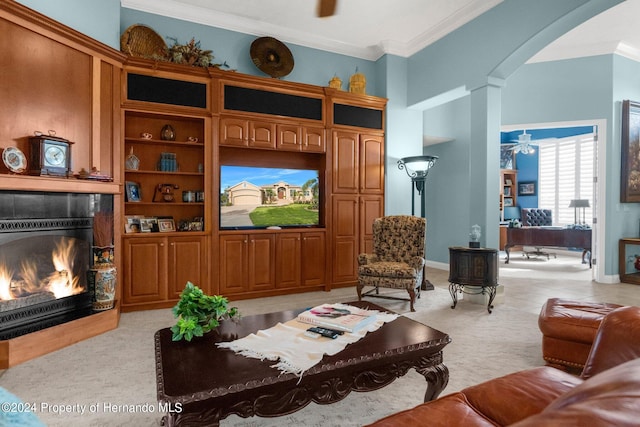 carpeted living room featuring ceiling fan, crown molding, and decorative columns