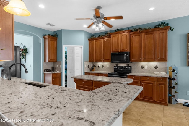 kitchen featuring black appliances, tasteful backsplash, light tile patterned floors, sink, and ceiling fan