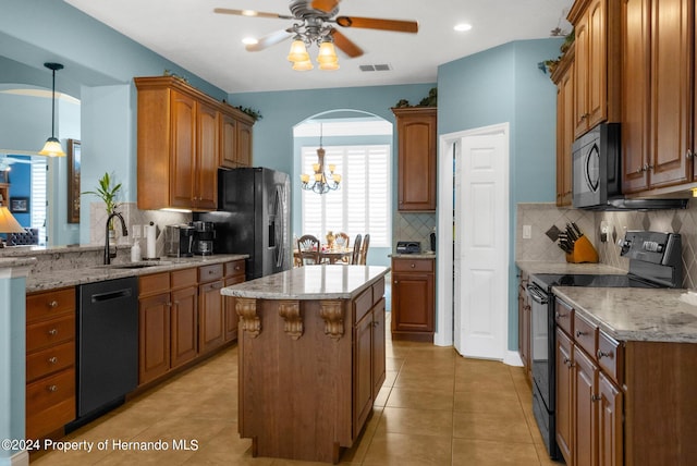 kitchen with black appliances, sink, a kitchen island, backsplash, and decorative light fixtures