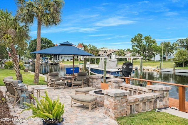 view of patio with a dock, a water view, and a fire pit