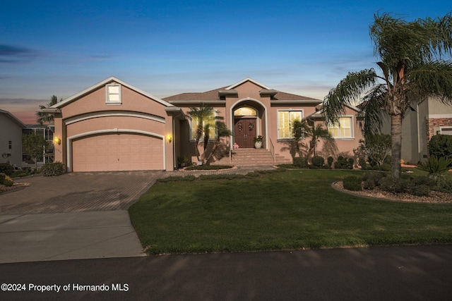 view of front of home with a garage and a yard