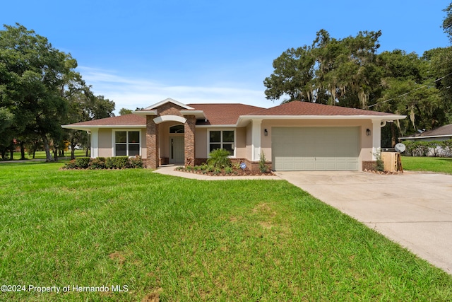 ranch-style home featuring a garage and a front lawn