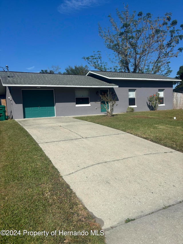 single story home featuring a garage and a front yard