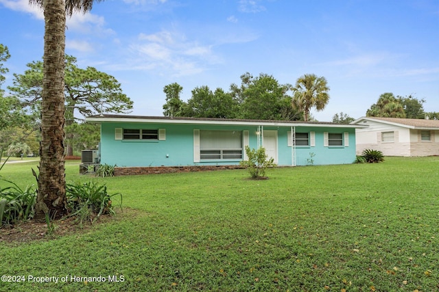 single story home featuring cooling unit and a front lawn