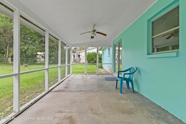 unfurnished sunroom featuring ceiling fan